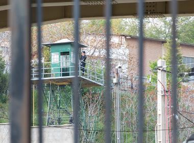 En vakt i ett vakttorn innanför Evin-fängelsets stängsel.