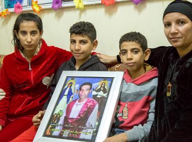 Ayads familj håller upp ett foto av honom. Ayad dödades i en attack mot en minibuss i Minya i Egypten våren 2017, när han vägrade att förneka sin tro på Jesus.