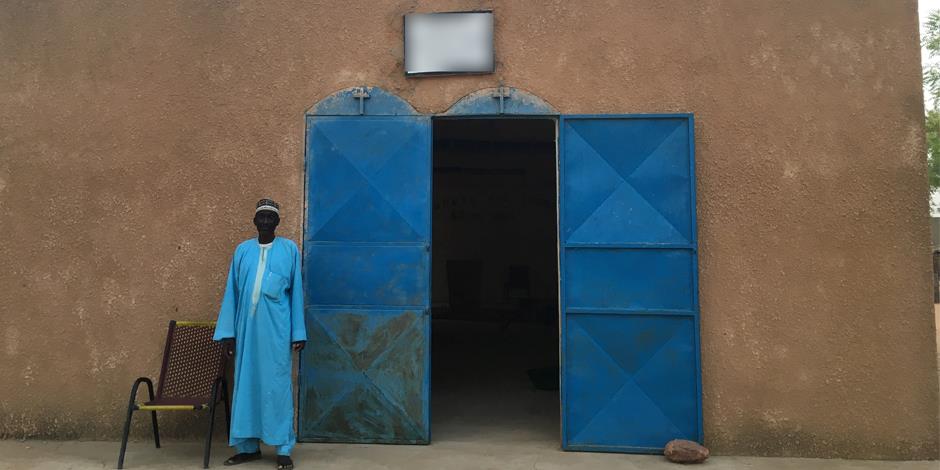 En man utanför en kyrka i Västafrika. (Personen på bilden har inget samband med texten). 
