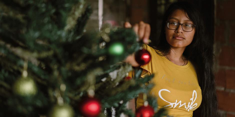 Valentina pyntar granen under sitt besök hemma hos familjen över jul. 