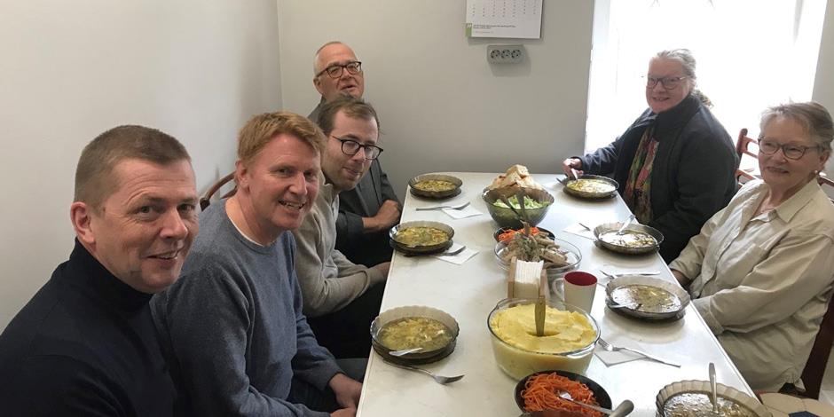 Anders (andra från vänster) äter mat tillsammans med de andra i resesällskapet. 